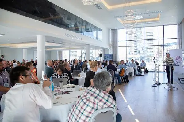 Speaker and audience in a large room at the event venue