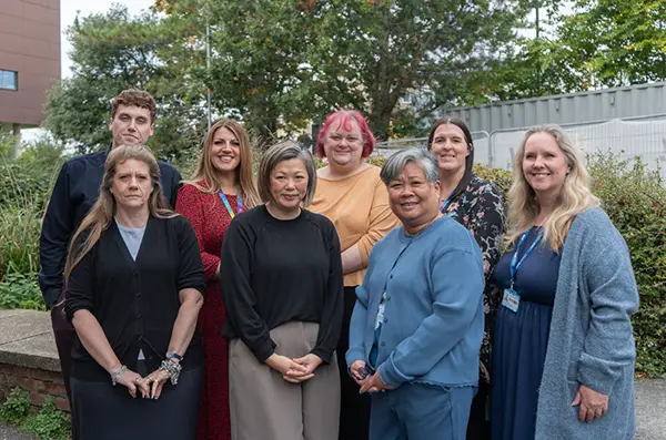 Group of staff standing outside smiling at the camera.
