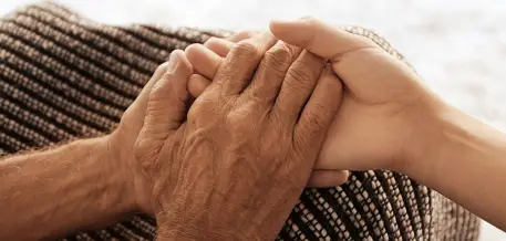 Old hands holding young hands close up