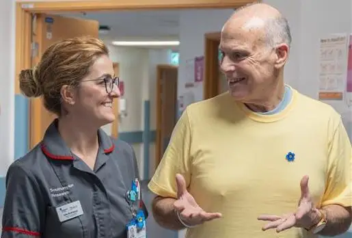 Inês and Alan talking in hospital corridor