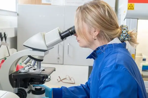 Anastasia looking down a microscope