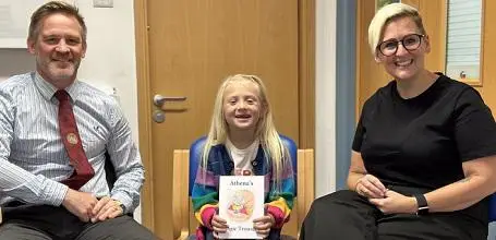 Athena with her mum and the surgeon who treated her