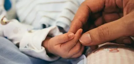 Baby holding hands with mother