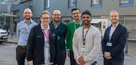 The UHS research team standing outside the main entrance to the hospital