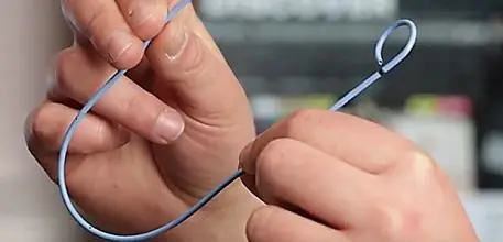 A person holding the new stent (thin u-shaped tube) 