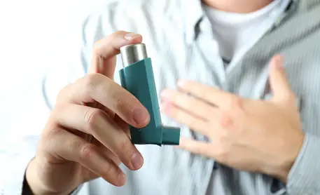 Man holding asthma inhaler