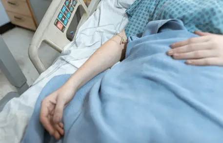 Blue blanket on patient lying in hospital bed