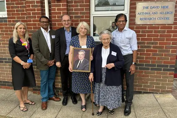 Professors Graham Roberts and Hasan Arshad in group next to plaque