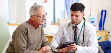 Doctor and older man looking at tablet