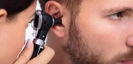 A doctor looking inside a patient's ear