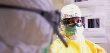 Two people in hazmat suits in conversation