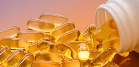 Fish oil capsules spilling out of a bottle