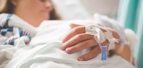 Female teenager in hospital bed with cannula