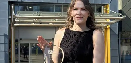 Helena Fisk holding her glass award outside the Univerist Hospital Southampton main entrance
