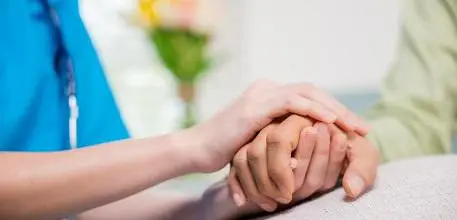 Old person holding hands with health professional
