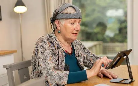 Woman wearing Cumulus headset and using tablet