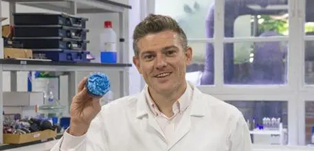 Professor Jon Swann holding a blue muffin