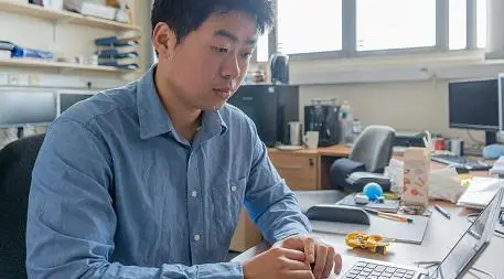 PhD student Lee Baker using laptop