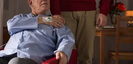 Man on a drip at home with relative