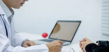 Man with laptop taking notes