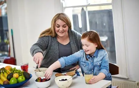 Mother preparing food for her daughter