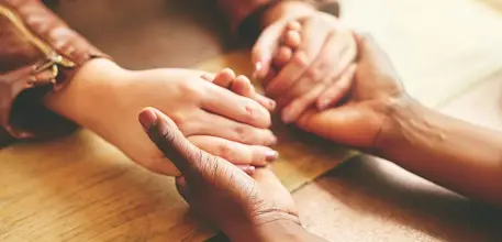 Close up of people holding hands in comfort