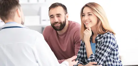 Young couple speaking to doctor