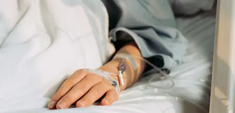 Patient's hand in hospital bed
