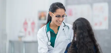Female doctor speaks to young girl