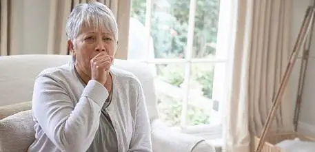 Older woman coughing at home