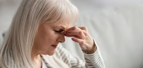 Woman holding the top of her nose in pain