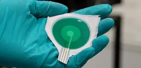 Gloved hand holding the device