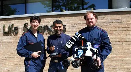 Hiroki Cook, Professor Sumeet Mahajan and Jake Kleboe pictured holding the replica Mars rover