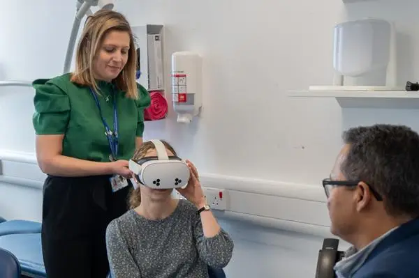 Dr Amelia Pietropaolo helping a person put on the VR headset