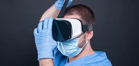 Surgeon wearing scrubs putting on a VR headset