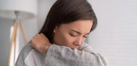 A young woman coughing